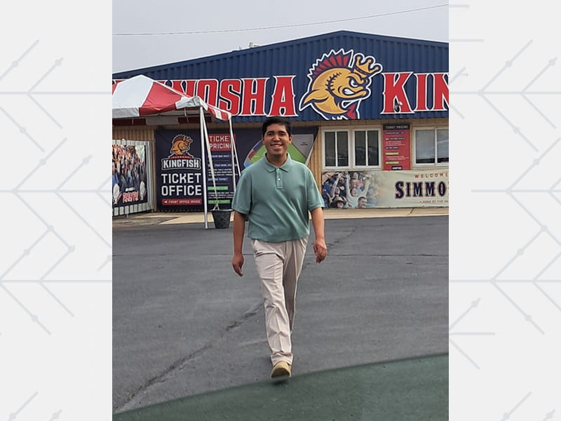 Manny Rios walking in front of the Kenosha Kingfish minor league baseball team ticket office