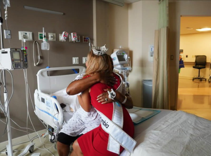 Jude Maboné hugging and giving words of encouragement to a patient in the hospital awaiting major surgery. (Photo courtesy of Jude Maboné)
