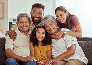 family smiling for camera while posed for a family photo