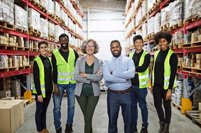 diverse warehouse workers smiling and posing in a group