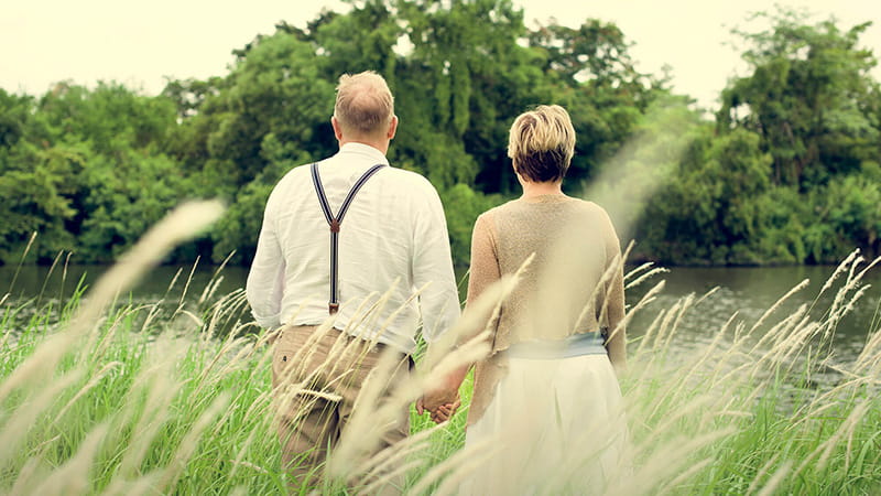 back of senior couple walking outdoors