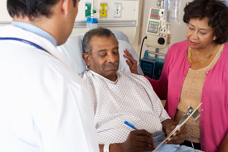 senior man signing for surgery in hospital bed