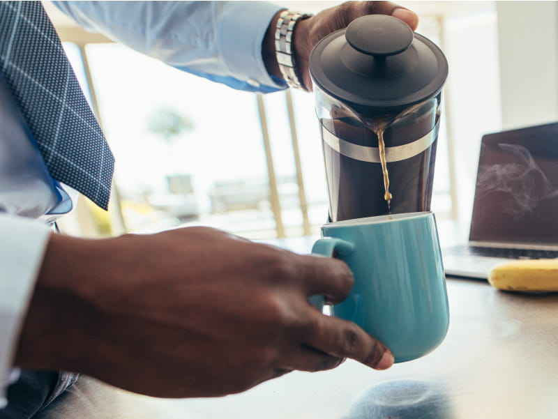 Man's hands pouring coffee. (Jacoblund/Getty Images)