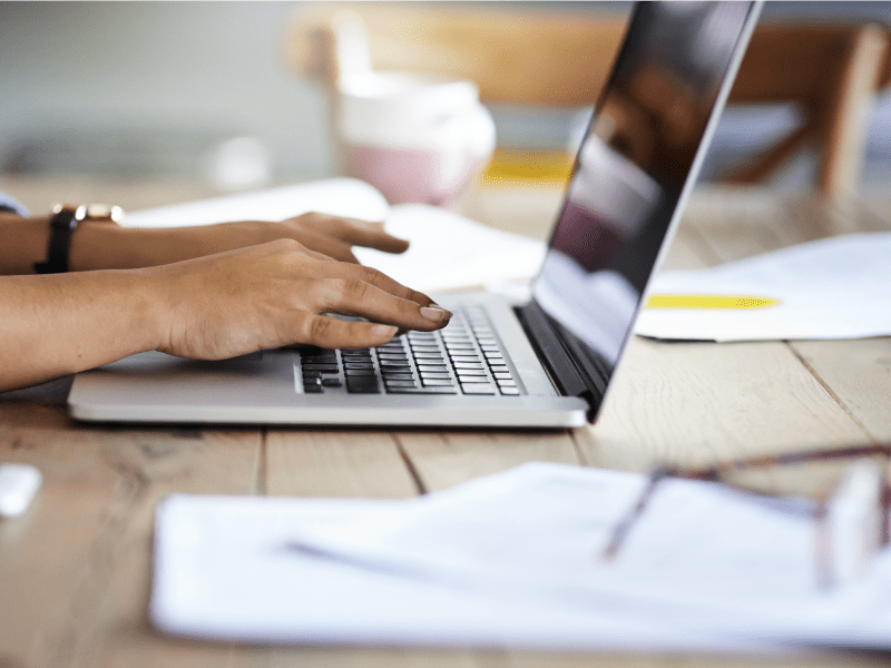 Woman typing on laptop.