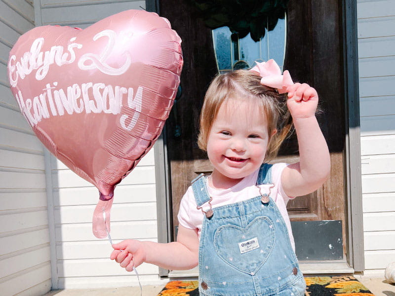 Three-year-old Evelyn Hamm holds a balloon celebrating her second 