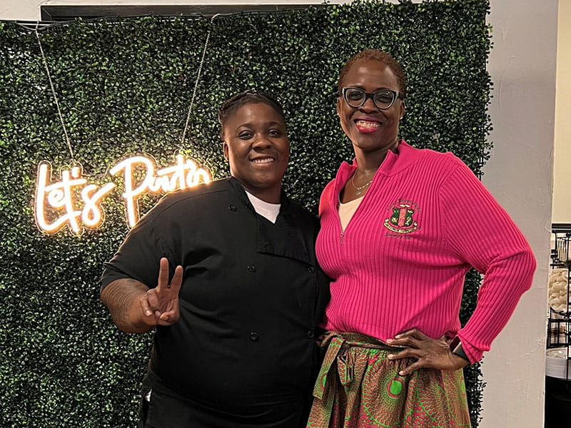 Sharnay posing with her mother Kim Spight, right, in front of a decorative backdrop