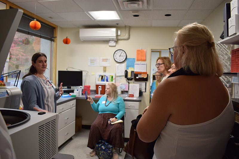 Framingham staff member Caitlin Vachon leads a lab tour during the study’s 75th‑anniversary open house.