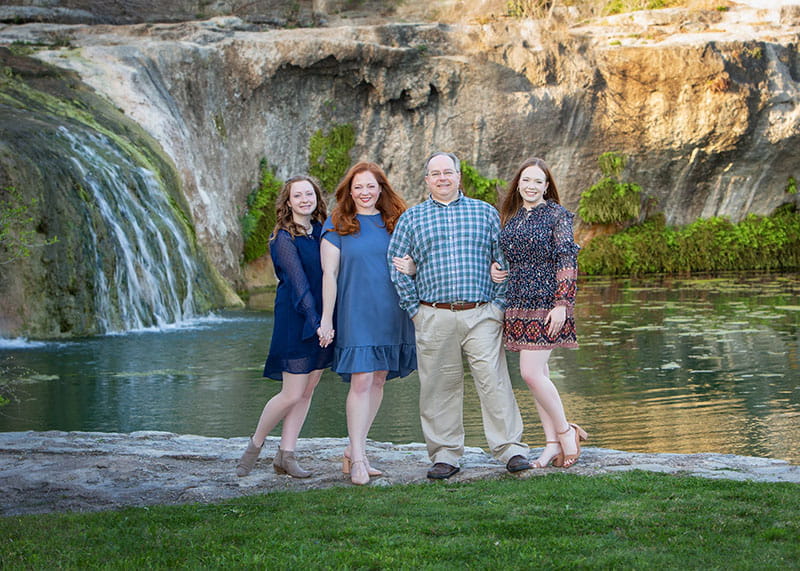 the Lowe family posing together in front of a waterfall