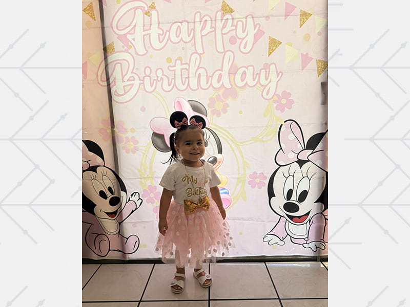 Aaliyah at her birthday, standing in a tutu with Minnie Mouse ears