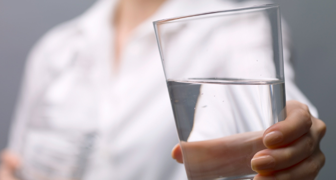 Woman holding glass of water