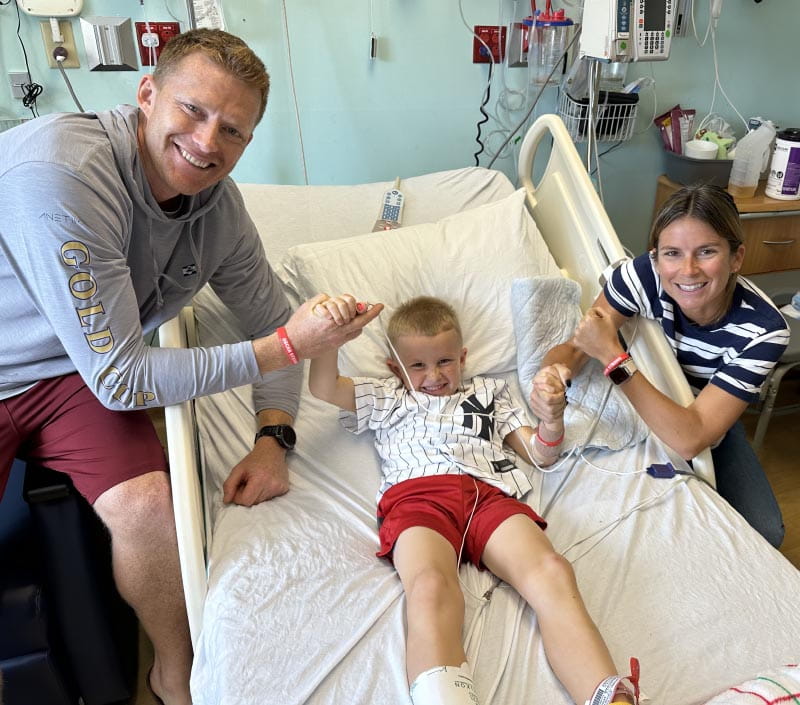 Oscar Stuebe (center) with his parents, Riley and Sarah, after he woke up in the hospital. (Photo courtesy of Sarah Stuebe)