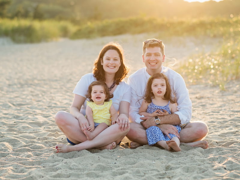 Melissa Russom and her husband, Braden, enjoy a beach vacation with their daughters in Cape Cod. The sisters, Kate (left) and Cora inherited a genetic heart condition called long QT syndrome. (Photo by Sarah Murray)