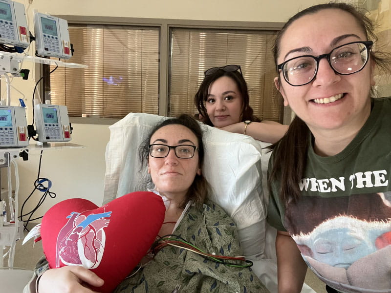 Hiba Jelahej recovering in the hospital after surgery and visiting with her sisters Farrah (front) and Yasmin Jelahej. (Photo courtesy of Hiba Jelahej)