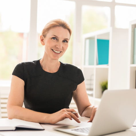 White woman sitting at desk with laptop
