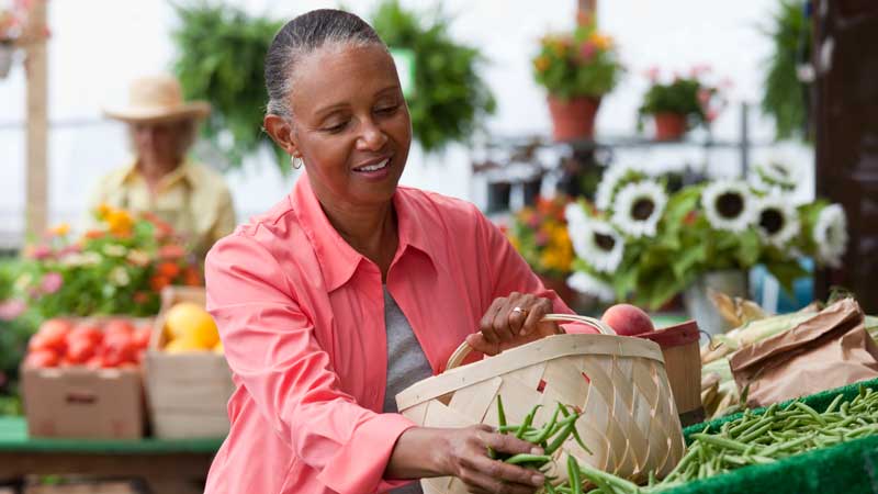 vrouw selecteert producten op boerenmarkt