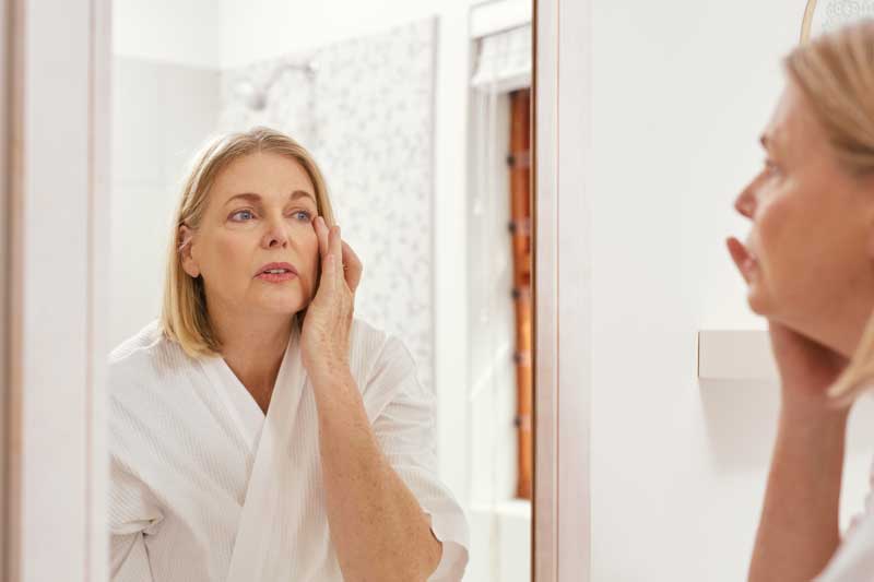 Femme regardant ses yeux dans un miroir