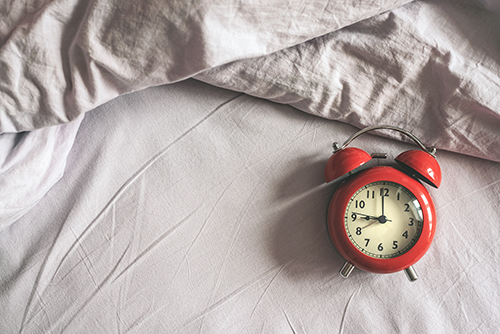 Alarm clock laying on a bed