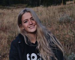 teenager smiling and sitting in field