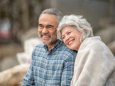 older couple smiling and looking off to the distance outside