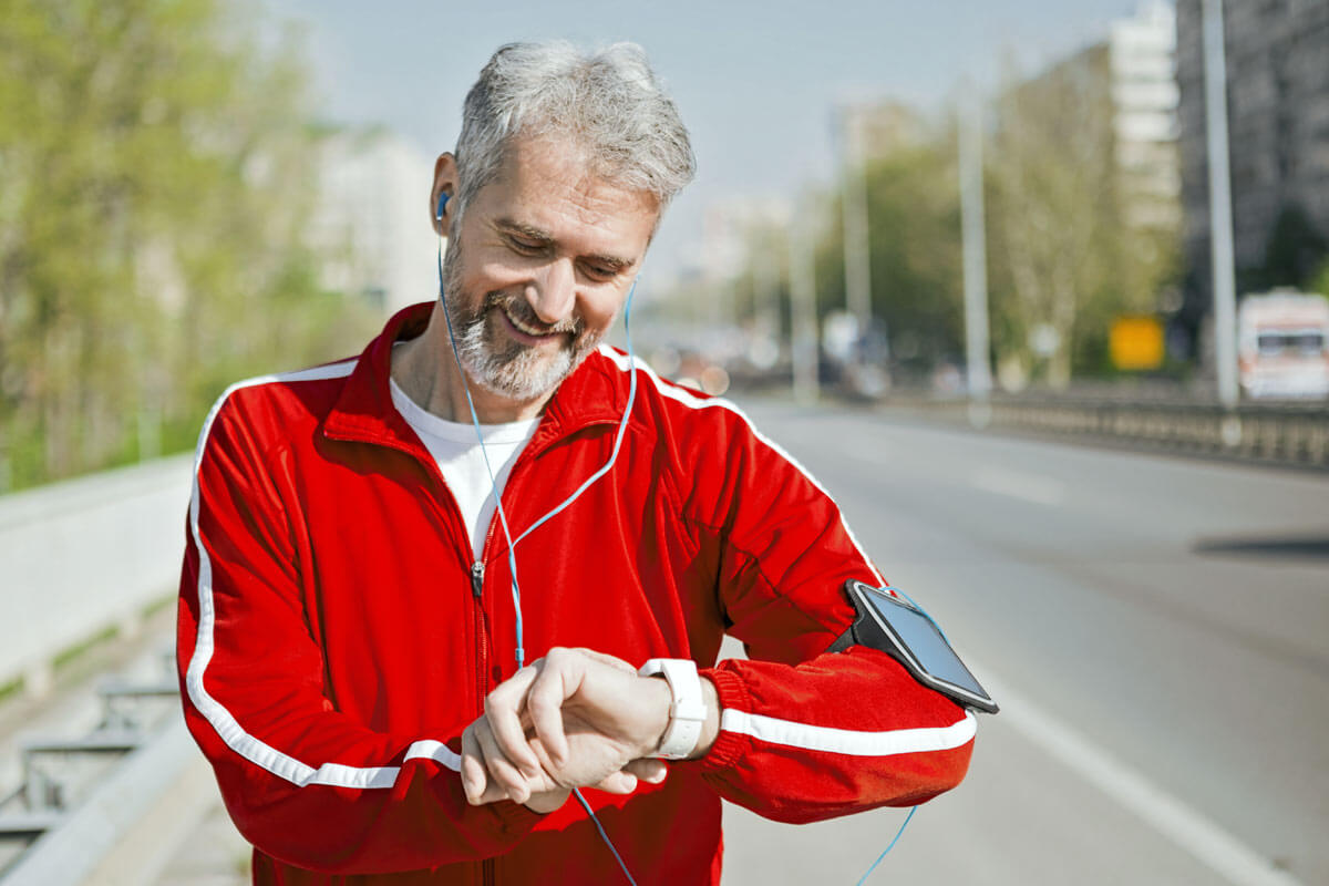 senior man in jogging suit checking his pulse