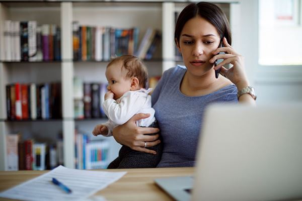 Busy working Mom on cell phone and laptop holding baby Busy working Mom on cell phone and laptop holding baby