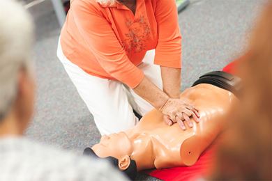 Teaching CPR on a manikin in a class setting Teaching CPR on a manikin in a class setting image